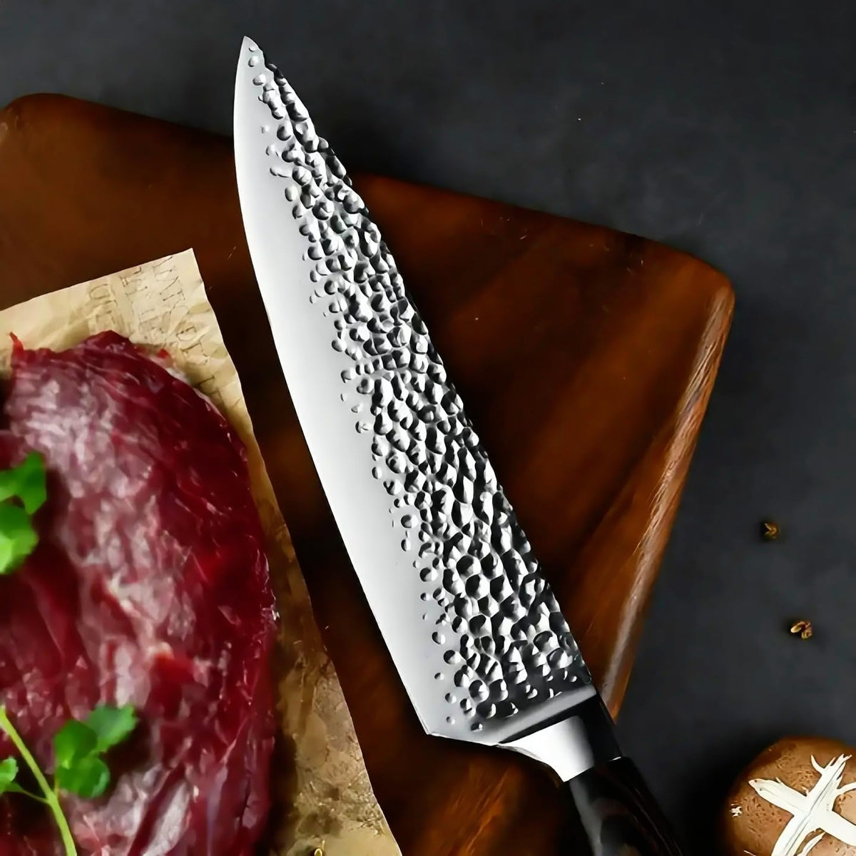 Elite Chefs 8-inch hammered chef knife on a walnut board beside a raw steak and fresh parsley